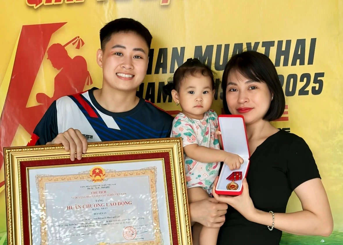 Nữ võ sĩ Muay Bùi Yến Ly: Giã từ đấu trường,獻 thân cho gia đình Bùi Yến Ly hạnh phúc bên vợ và con trong ngày nhận Huân chương Lao động hạng nhất. Ảnh: NVCC.