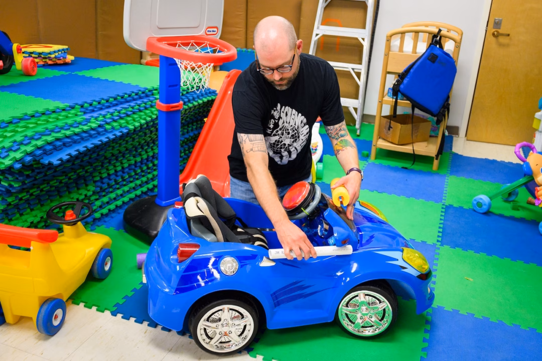 Associate Professor Sam Logan demonstrates how he and his colleagues retrofit toy cars for the program Go Baby Go in his Oregon State University classroom.High School Journalism Institute