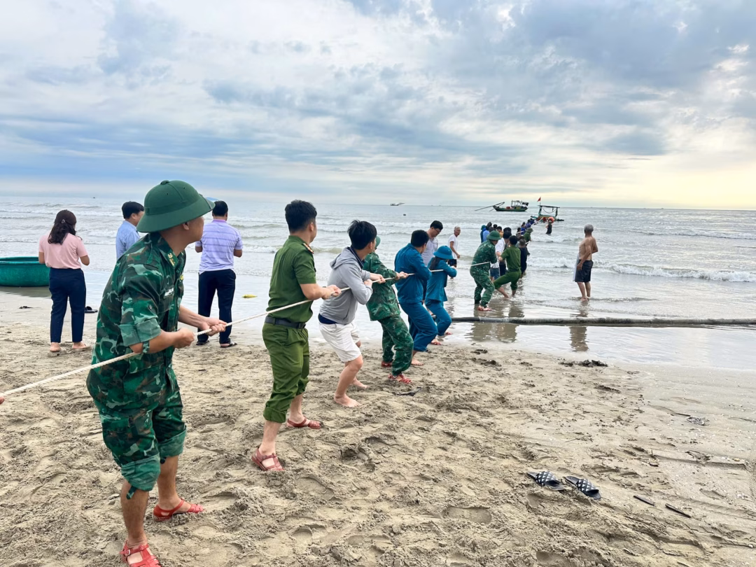 Mưa lớn, sóng to, tàu cá chở 34 người bị chìm, 1 người đuối nước Lực lượng phối hợp kéo tàu thuyền lên vào rạng sáng 20/7. Ảnh: BĐBP.