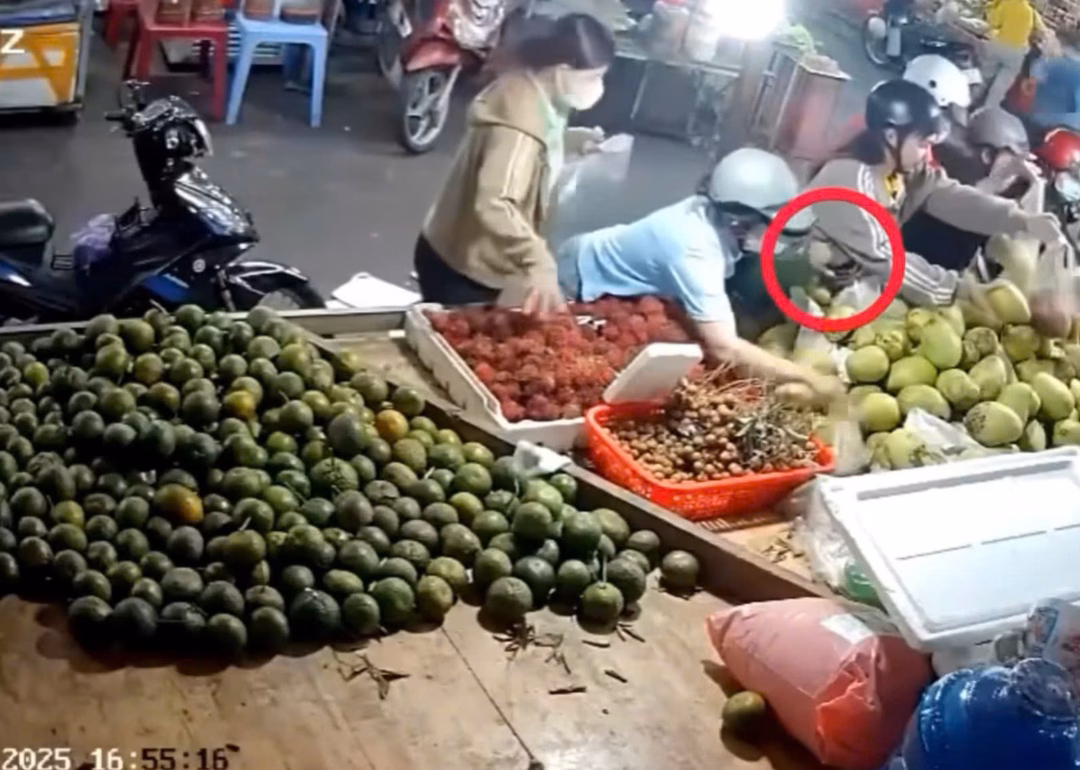 Người nữ đội mũ bảo hiểm (thứ 2 từ trái qua) móc túi nữ công nhân lấy cái bóp