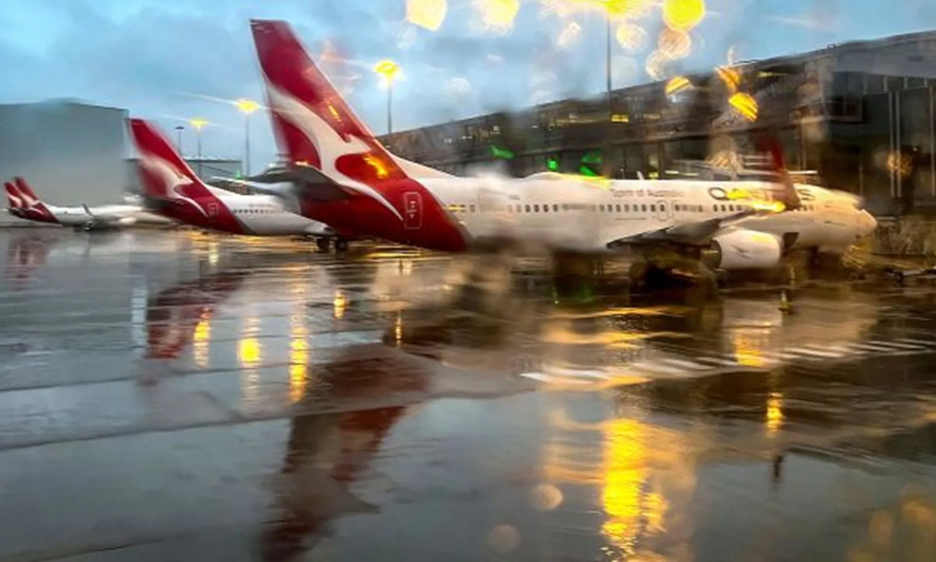 Máy bay Boeing 737 của Qantas Airlines Máy bay Boeing 737 của Qantas Airlines đậu tại nhà ga nội địa của sân bay Sydney vào một ngày mưa.