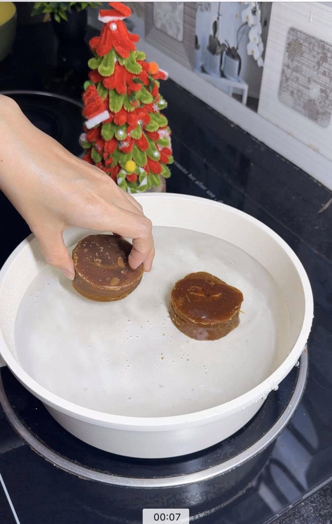 Đun s&ocirc;i 1,5 l&iacute;t nước c&ugrave;ng 2 vi&ecirc;n đường thốt nốt.