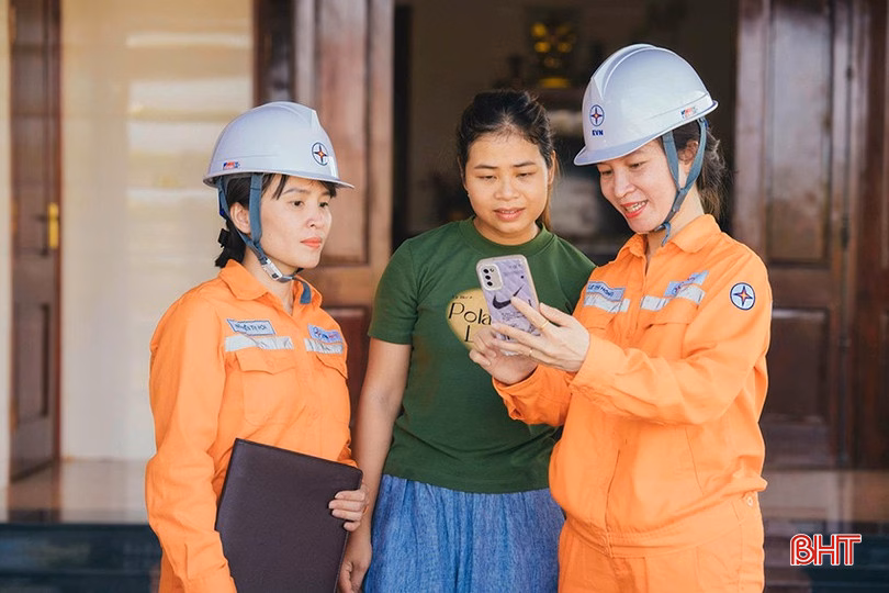 Nhân viên Công ty Điện lực Hà Tĩnh hướng dẫn khách hàng cài app chăm sóc khách hàng để tiện sử dụng các dịch vụ của ngành.