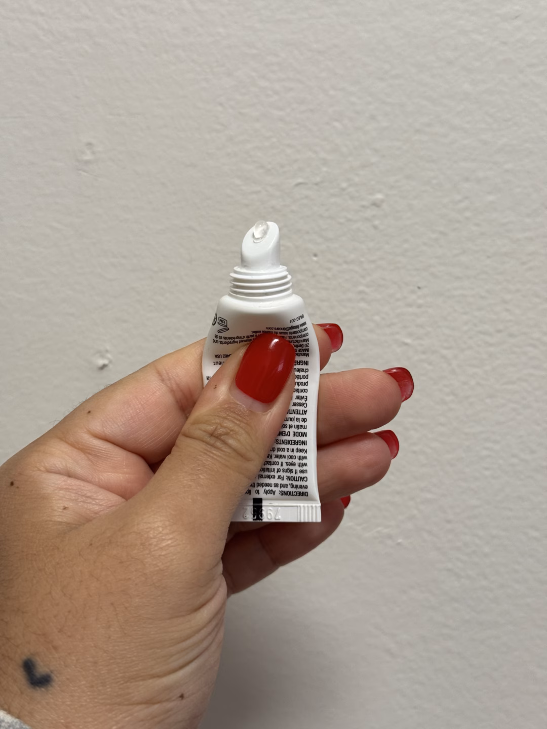 Son dưỡng ẩm môi đắt đỏ được sao Mỹ ưa chuộng A hand squeezing lip gloss out of a tube