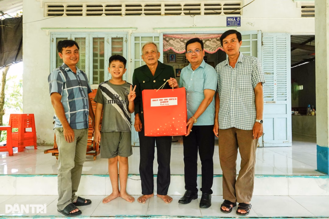 Ông Trương Thanh Giang (đeo kính), Phó Chủ tịch UBND xã Nhơn Mỹ, thăm hỏi, tặng quà gia đình thương binh Nguyễn Văn Chiến (Ảnh: Bảo Kỳ).