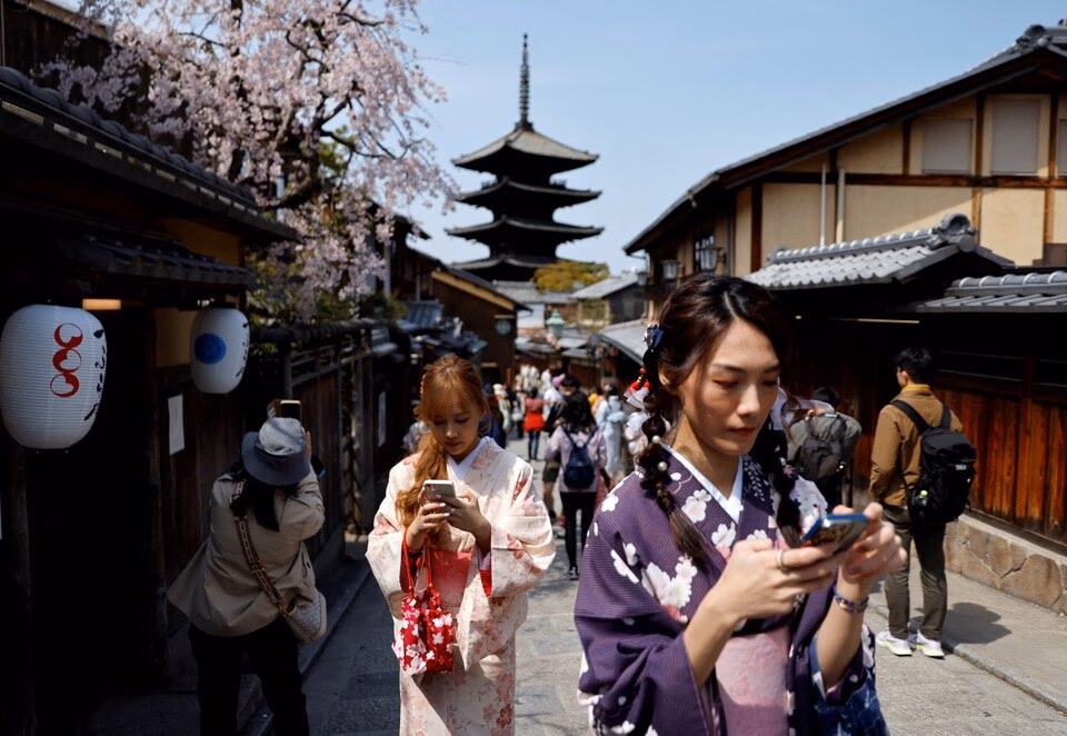 Du khách chụp ảnh selfie tại làng cổ Bukchon Hanok ở Seoul, Hàn Quốc, năm 2024. Các chuyên gia nhận định những điểm đến gần như Hàn Quốc và Đài Loan sẽ tiếp tục được du khách Nhật ưa chuộng. Ảnh: Reuters.