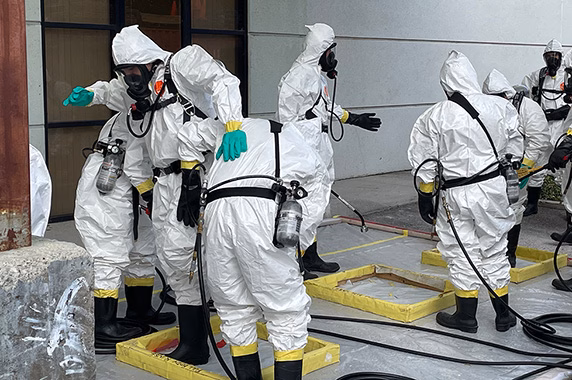 WTP trainees learn how to decontaminate full-body PPE.