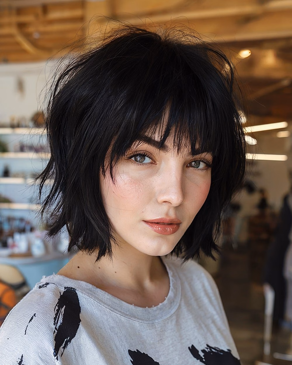 Textured chin-length black bob with piecey fringe and jagged ends