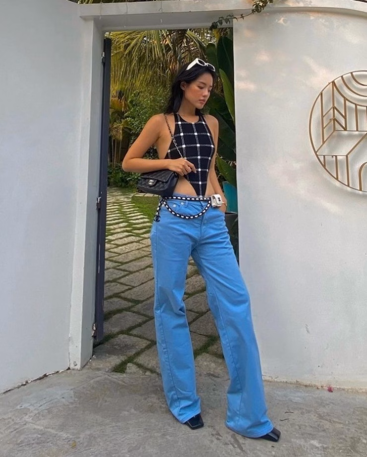 Đồ tắm khoét hông khoe triệt để vóc dáng được Khánh Linh phối với quần jeans và loạt phụ kiện Chanel tăng vẻ sành điệu.