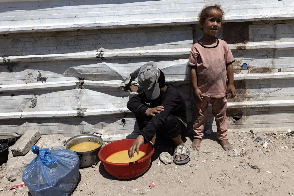 2 triệu dân Gaza cận kề nạn đói vì xung đột với Israel Hai em nhỏ đứng bên ngoài một bếp ăn từ thiện ở thành phố Gaza, ngày 23/7/2025. Ảnh: NY Times