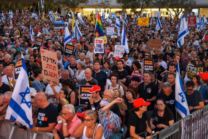 Đám đông người biểu tình tại Tel Aviv (Israel) giương cao biểu ngữ và cờ kêu gọi chấm dứt cuộc chiến ở Gaza và trả tự do cho những con tin Israel bị Hamas bắt giữ tại Gaza - Ảnh: AFP