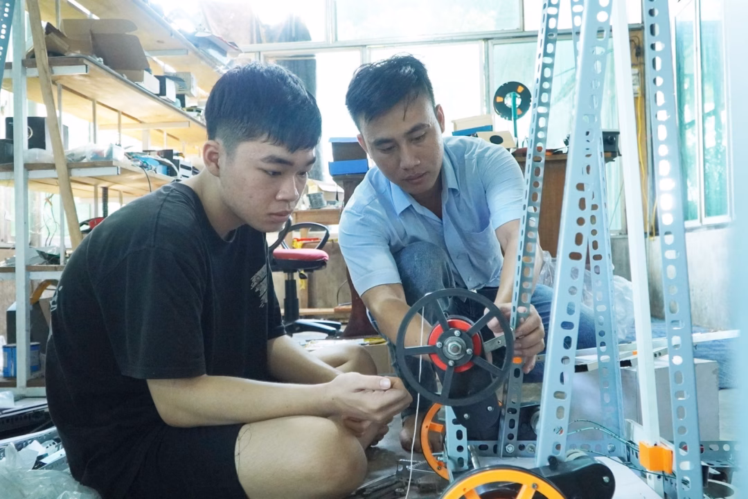 Anh Lập hướng dẫn học sinh lắp ráp robot. Ảnh: PHAN VINH