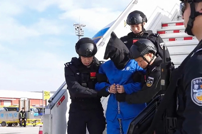 Chen Zhi bị áp giải tại sân bay Bắc Kinh Cảnh sát Trung Quốc áp giải Chen Zhi rời máy bay tại Bắc Kinh ngày 8/1