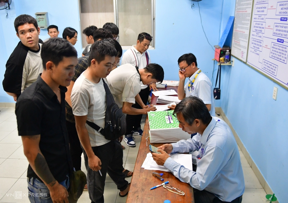 TP HCM tổ chức thi bằng lái xe đêm lẫn ngày để giải quyết tồn đọng Ở phòng bên cạnh sân chạy sa hình, nhiều thí sinh đứng vây quanh nhân viên làm hồ sơ để lấy số thứ tự thi.