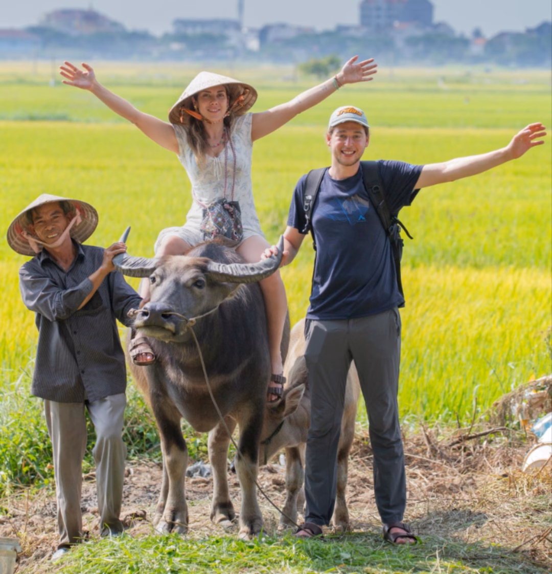 Du khách hào hứng trải nghiệm dịch vụ du lịch ở mùa lúa chín của Hội An. Ảnh: Phan Vũ Trọng