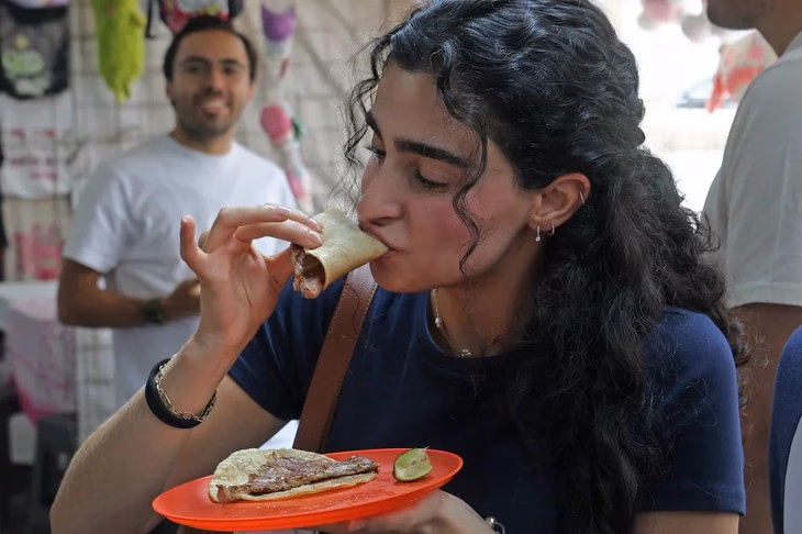 Tiệm taco bình dị trở thành nhà hàng một sao Michelin đầu tiên ở Mexico Một thực khách đang thưởng thức món taco tại nhà hàng - Ảnh: AFP