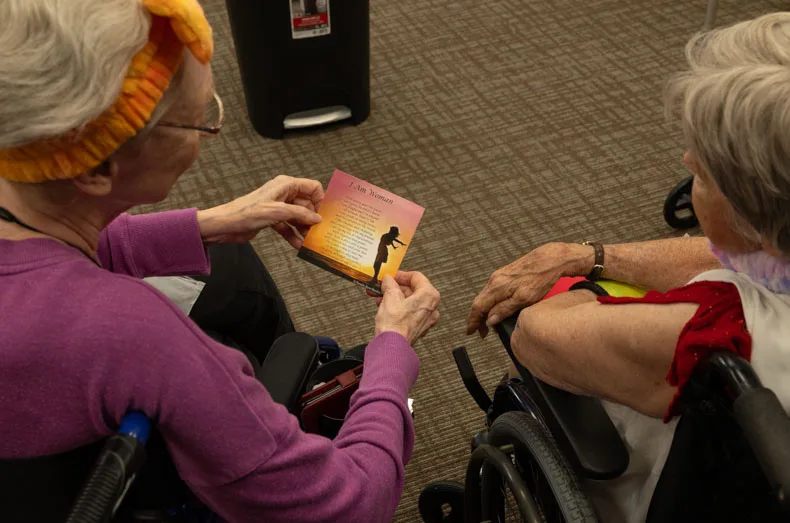 Residents read the message written on a card included in their gift bags. Gorgeous Grandmas Day was both a chance to pamper residents and a celebration of womanhood. Photo credit Julian Schnittker.