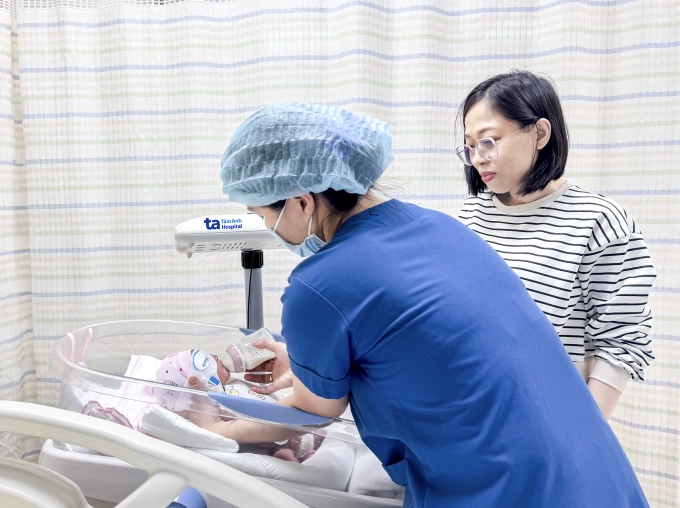 Chị Ngọc được nhân viên y tế BVĐK Tâm Anh hướng dẫn chăm sóc con gái trước khi xuất viện. Ảnh: Hoài Thương