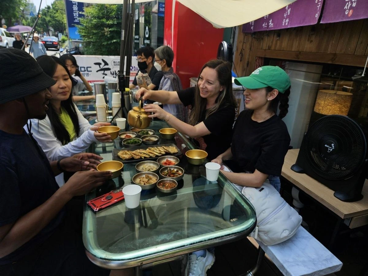 Du khách thử makgeolli (rượu gạo truyền thống của Hàn Quốc) và jeon (bánh xèo Hàn Quốc) tại một nhà hàng sau khi đi bộ đường dài ở Seoul. Nguồn: Korea Times
