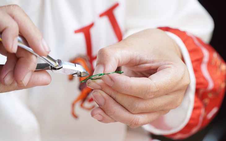 Đôi tay khéo léo chị Phúc đã làm nên nhiều sản phẩm nhỏ bằng cây kim, sợi tóc, hạt đậu - Ảnh: THANH HUYỀN