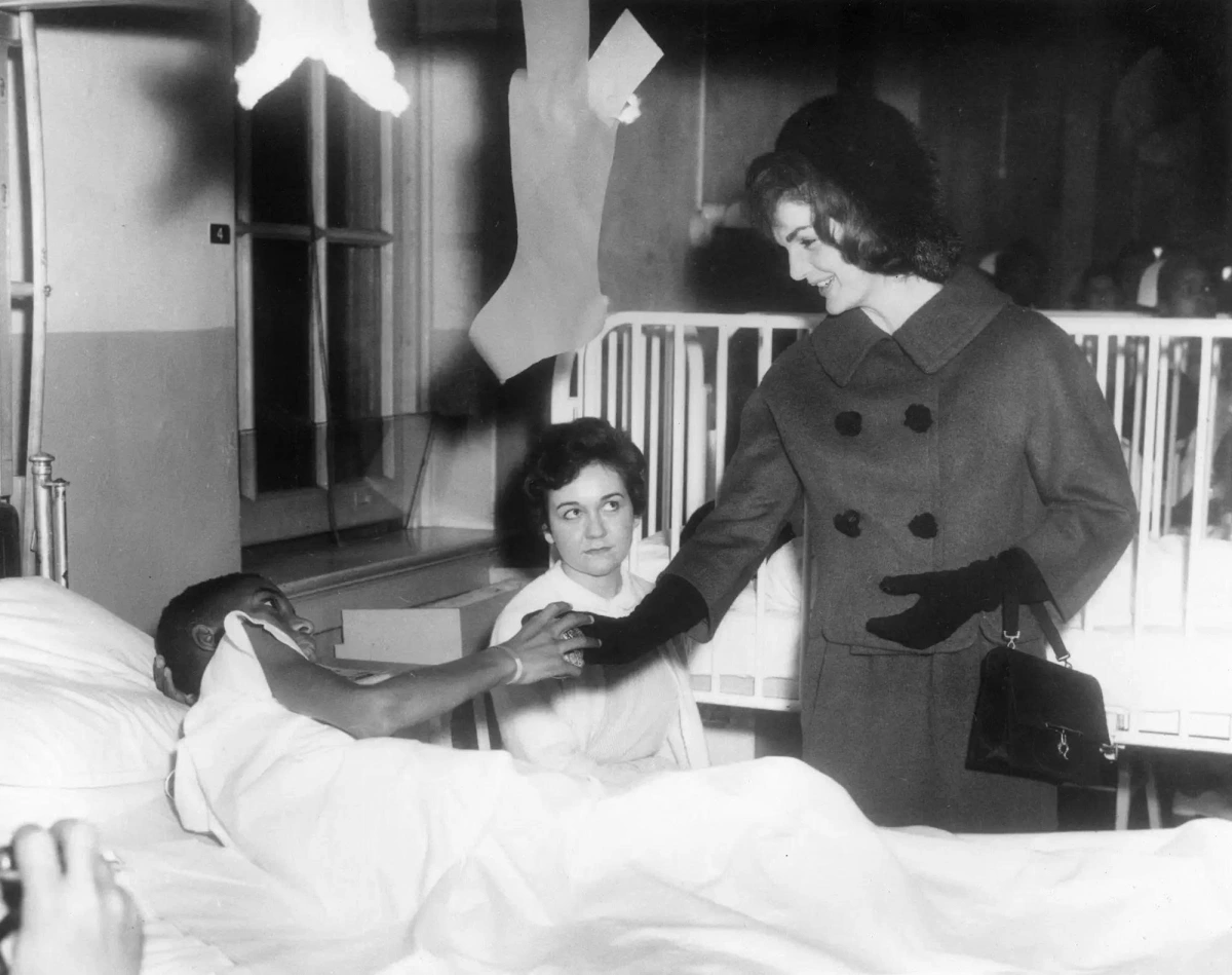 Ngày 12/12/1961, phu nhân Jackie tới thăm một bệnh viện dành cho trẻ em. Bà trò chuyện và nắm tay một bé trai đang nằm viện, diện chiếc áo khoác dạ cổ điển cùng mũ, găng tay và túi xách, đúng phong cách đậm chất Jackie.