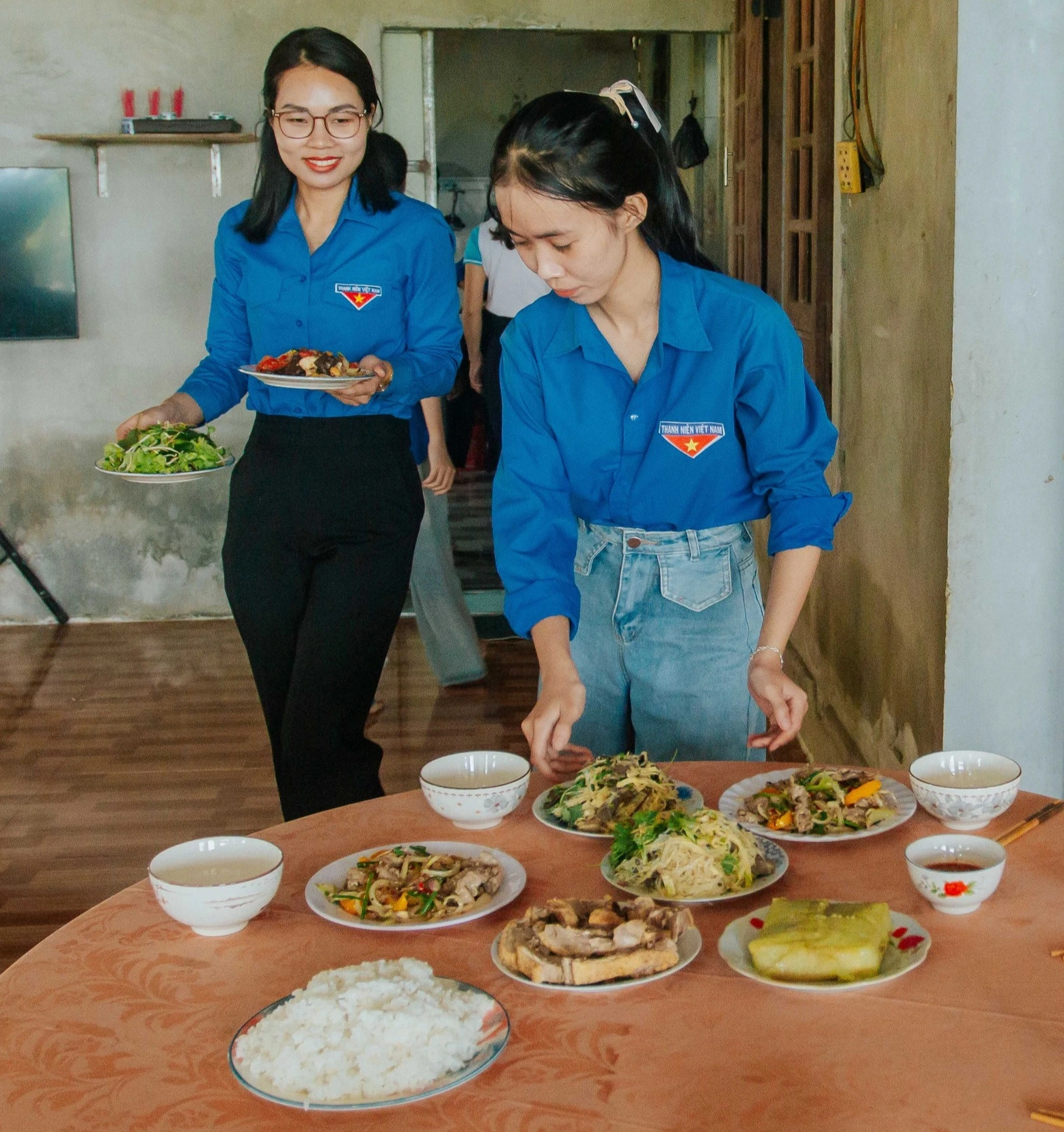 Các đoàn viên, thanh niên sửa soạn mâm cơm tại gia đình của Mẹ Việt Nam anh hùng Đặng Thị Thỉ