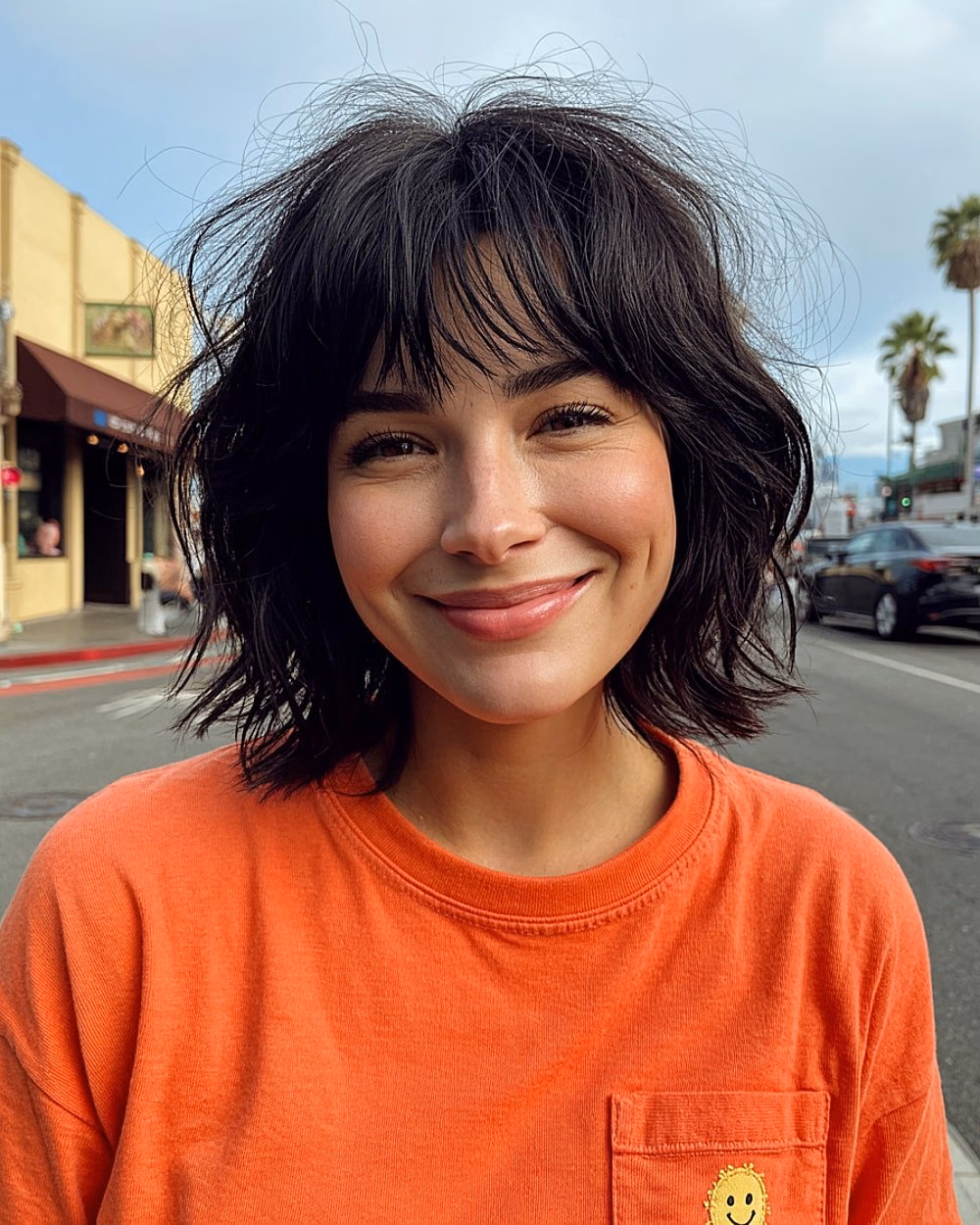 Messy tousled short black bob with airy bangs and natural waves