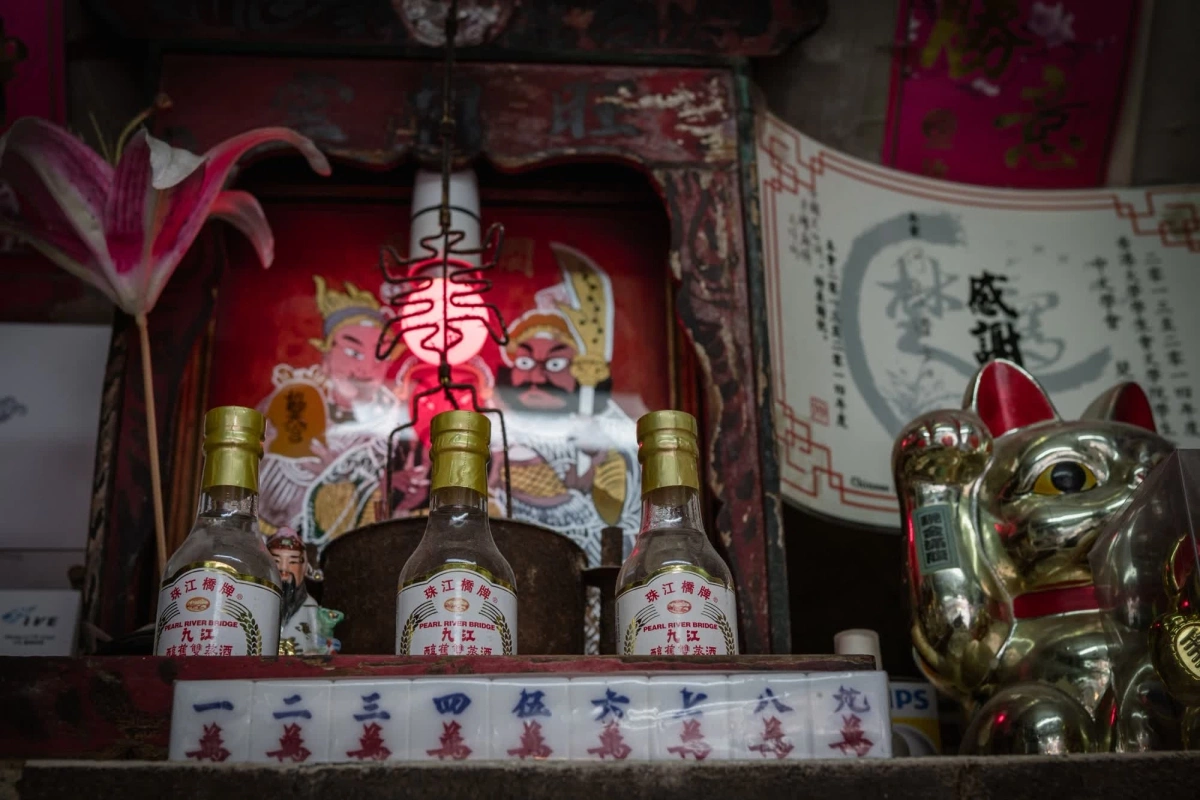 Sau ghế làm việc của bà là một bàn thờ nhỏ phát ra ánh sáng đỏ mờ. Phía trước bàn thờ đặt một bộ cờ mạt chược.