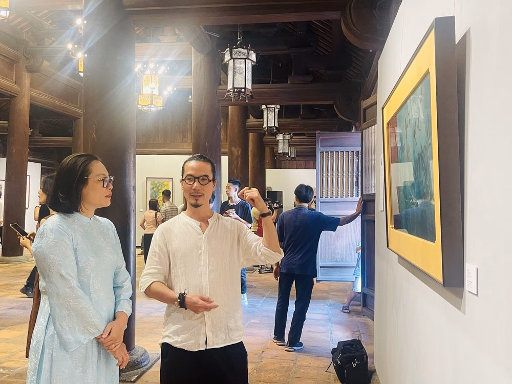 Họa sỹ Trường Thịnh trao đổi với đại diện Ban tổ chức về các tác phẩm trưng bày tại triển lãm