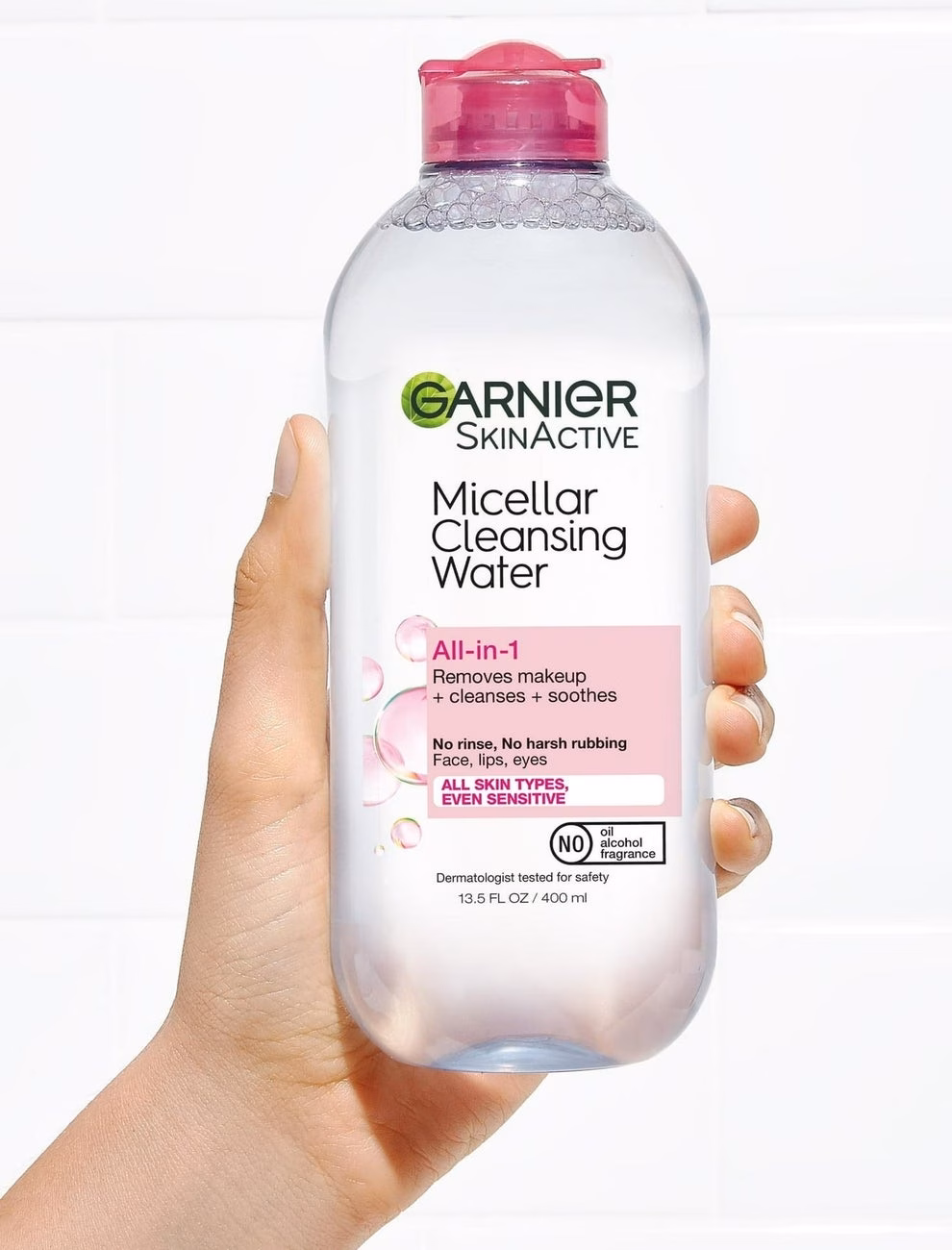 3 sản phẩm chăm sóc da đáng tiền nên đầu tư ngay Hand holding Garnier SkinActive Micellar Cleansing Water bottle; highlights cruelty-free, fragrance-free, derm-tested, and oil-free features