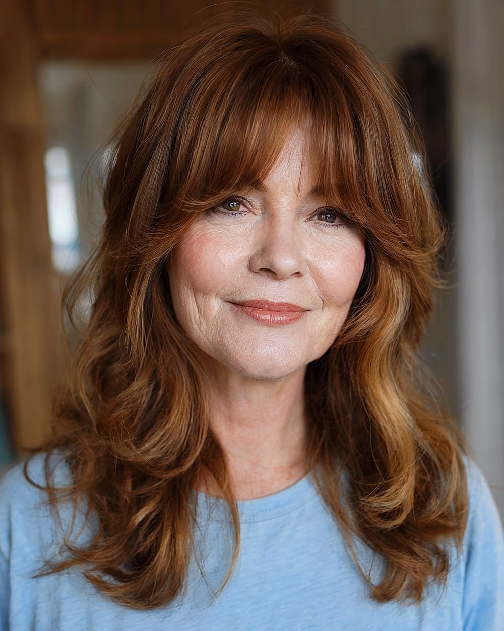 Cắt tóc layer trung giúp chị em U60 trẻ trung, dễ chăm sóc Medium layered auburn haircut with curtain bangs and soft waves for older women