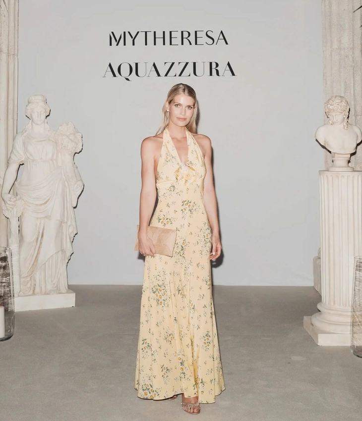 Giới thiệu về Kitty Spencer: Người mẫu hoàng gia với phong cách quý tộc Kitty Spencer xuất hiện rạng rỡ với chiếc váy Rodarte xẻ ngực màu vàng bơ, in hoa và điểm xuyết một chiếc ghim hoa hồng tinh tế trong bữa tiệc tối được tổ chức vào đầu tháng 7 trong một ngôi đền La Mã cổ đại. Cô phối cùng clutch đan raffia và đôi sandal đính đá lấp lánh của Aquazzura - Ảnh: Lucas Possiede
