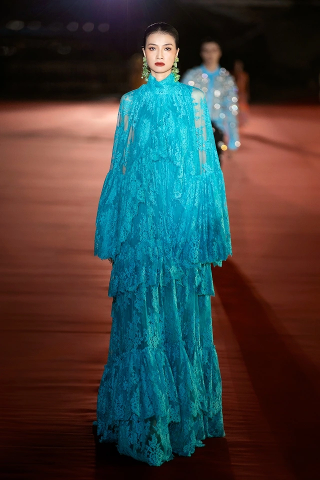 Tiểu Vy làm vedette ở sàn runway bên sông Hàn Gam màu xanh sky blue chủ đạo mang lại cảm giác mát dịu, được phối táo bạo cùng hồng neon, xanh, và trắng tạo nên tổng thể hút mắt