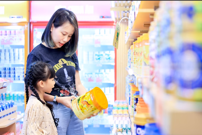 Thúy Ngân cùng con gái tại cửa hàng Vinamilk. Cô cho biết cả hai con của mình đều sử dụng sản phẩm Otimum. Ảnh: Nguyễn Hoàng