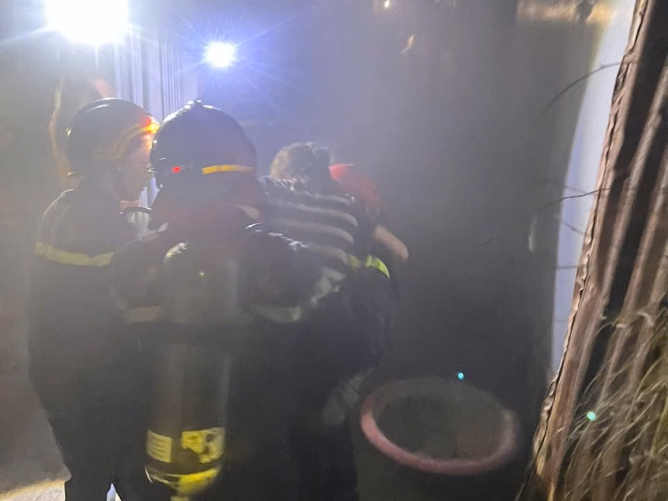 Nổ bình gas trong nhà, hai người được cứu thoát Lính cứu hoả đưa 2 nạn nhân mắc kẹt trong căn nhà cháy ra ngoài an toàn. Ảnh: MĐ.