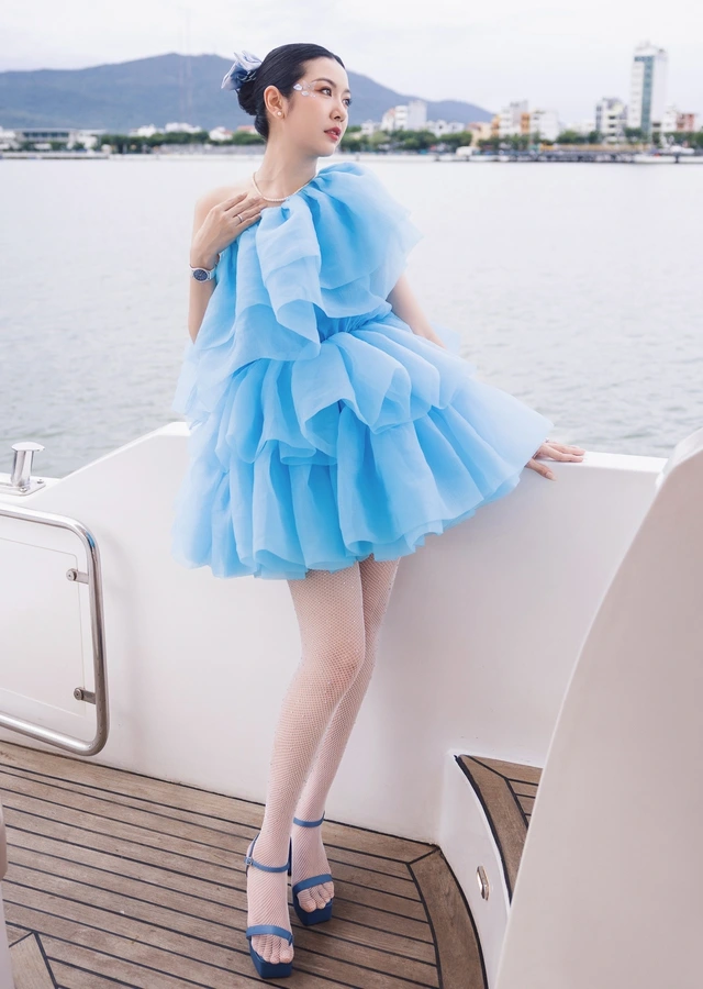 Xu hướng thời trang đầm xanh da trời trong thiết kế đồng phối mới lạ Đầm công chúa lệch vai xếp tầng mềm mại, dịu dàng phối cùng xăng đan cao gót dây mảnh tông xanh đậm và tất lưới mỏng là gợi ý mặc đẹp sành điệu như fashionista chính hiệu