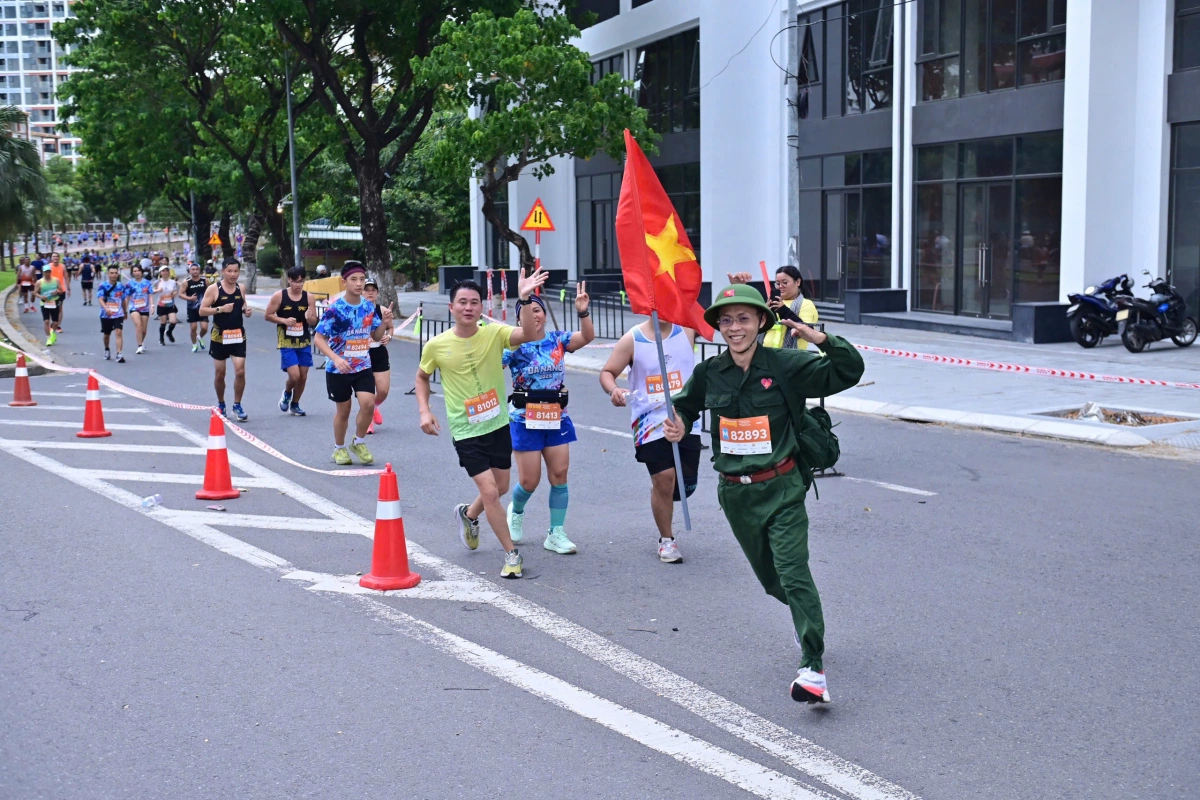 Runner Võ Đức Dương tạo hình chú bộ đội cầm cờ tổ quốc hành quân khi chạy 21km.
