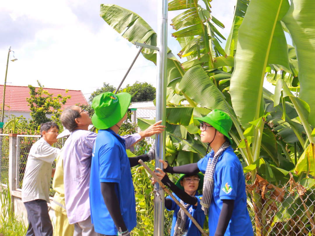 Sinh viên tình nguyện cùng người dân làm công trình thắp sáng đường quê.