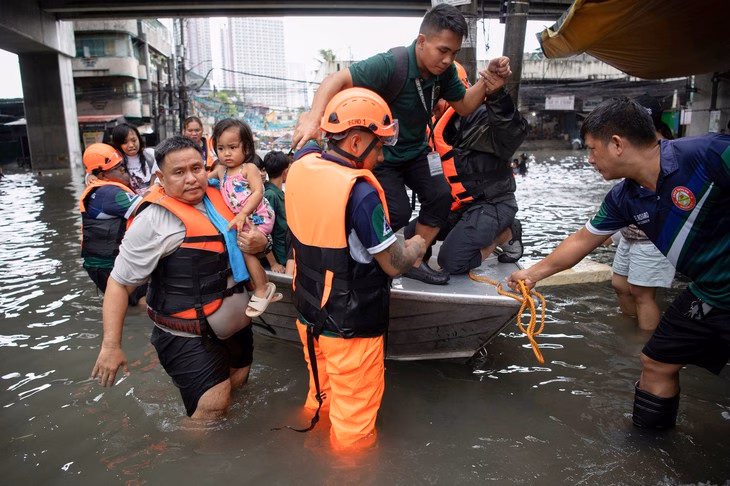 Lực lượng cứu hộ giải cứu những người bị mắc kẹt do lũ lụt tại Manila ngày 21-7 - Ảnh: AFP