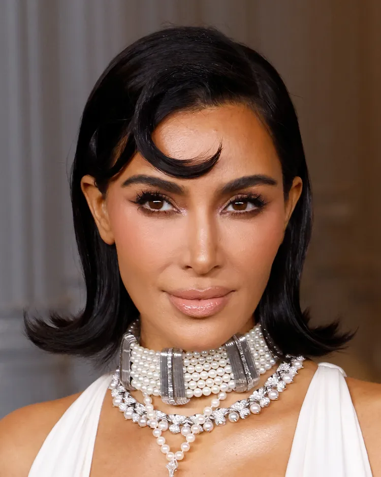 Cách tạo kiểu tóc uốn lật đẹp tại nhà theo bí quyết của thợ cắt tóc Hollywood Kim Kardashian in a white dress with pearl necklaces and her short hair in a flip hairstyle