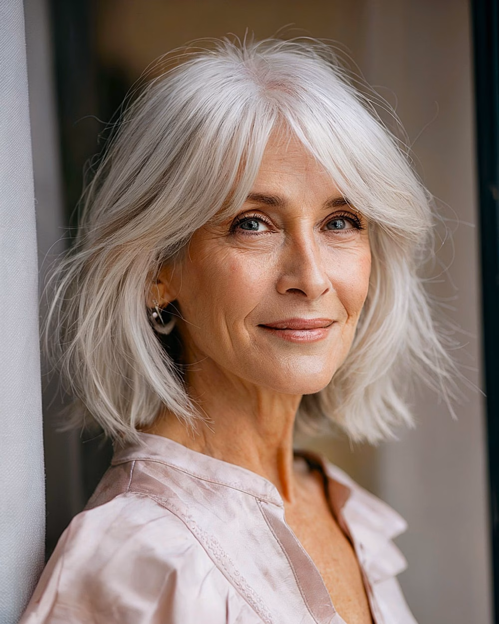 Textured silver bob with curtain bangs in a soft Silverveil haircut for mature women