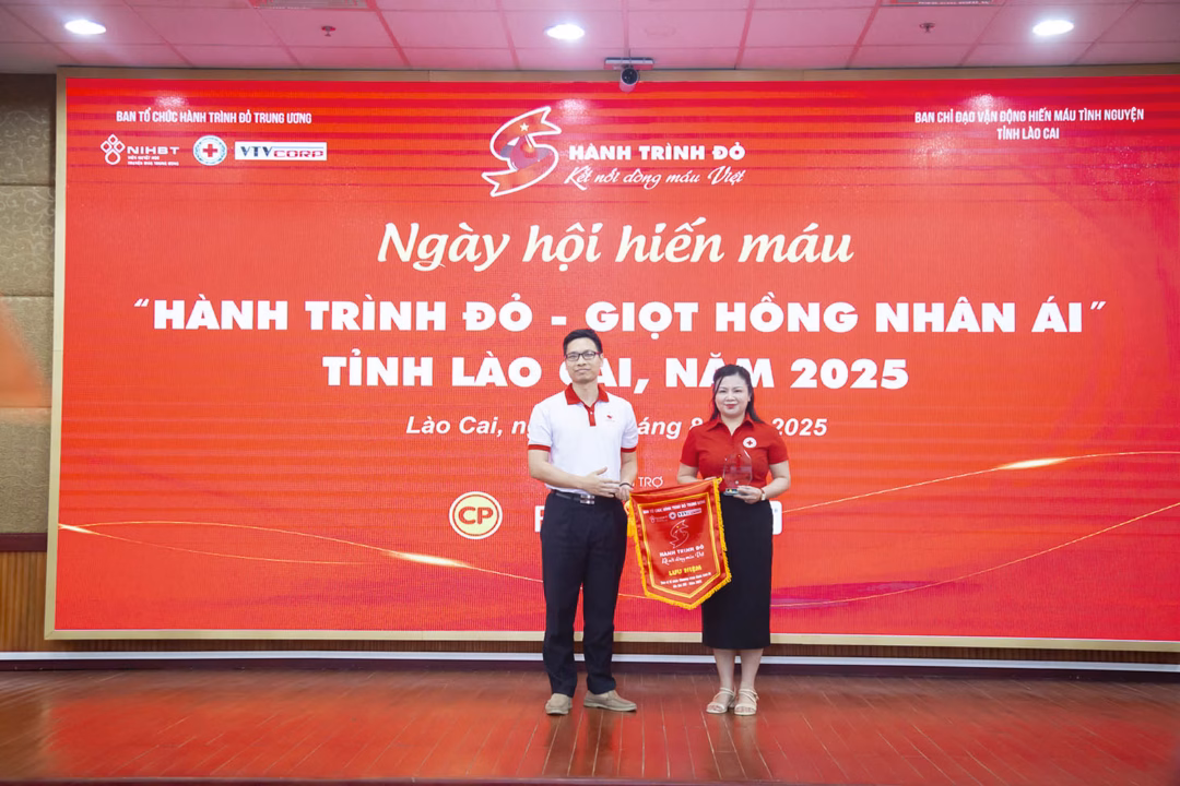 Lãnh đạo Trung tâm Máu Quốc gia, Viện Huyết học – Truyền máu Trung ương trao cờ lưu niệm của chương trình cho Ban tổ chức Hành trình Đỏ tỉnh Lào Cai.