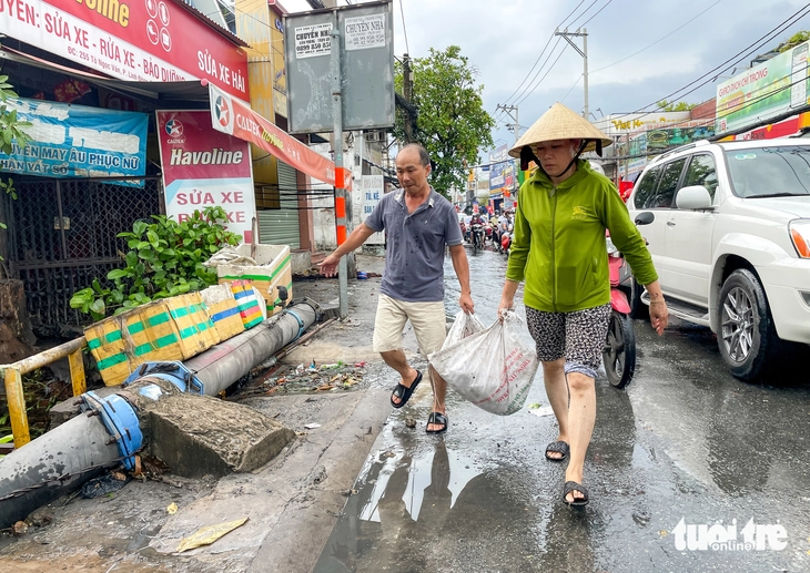Giải pháp chống ngập cho chợ Thủ Đức Người dân tìm cách vớt rác ở các cửa xả để nước có thể thoát bớt
