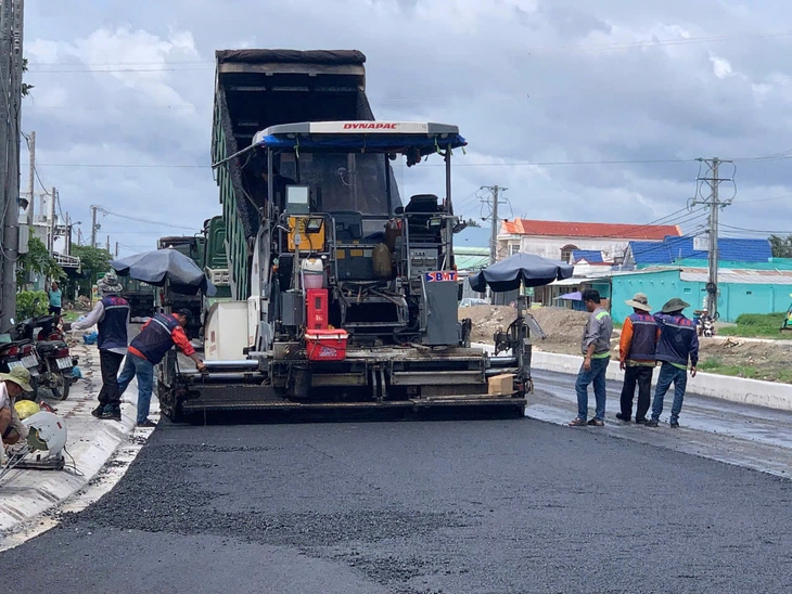 Công nhân thảm nhựa đường dẫn lên cầu Công nhân thảm nhựa đường dẫn lên cầu