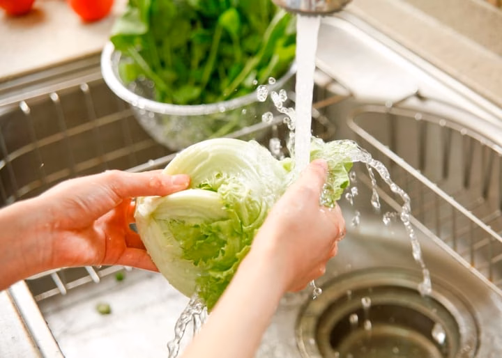 Rửa rau dưới vòi nước chảy Rửa rau dưới vòi nước chảy giúp loại bỏ bụi bẩn và dư lượng thuốc trừ sâu.