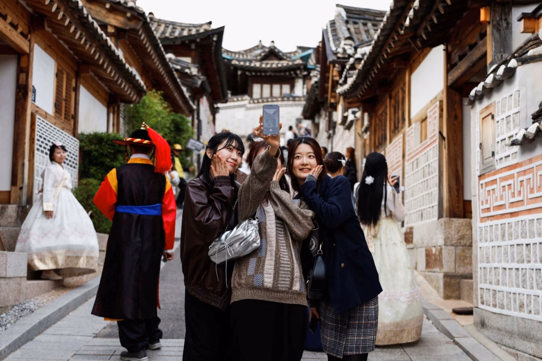 Người Nhật giảm sở hữu hộ chiếu do chi phí cao và lo ngại an toàn Du khách chụp ảnh selfie tại làng cổ Bukchon Hanok ở Seoul, Hàn Quốc, năm 2024. Các chuyên gia nhận định những điểm đến gần như Hàn Quốc và Đài Loan sẽ tiếp tục được du khách Nhật ưa chuộng. Ảnh: Reuters.
