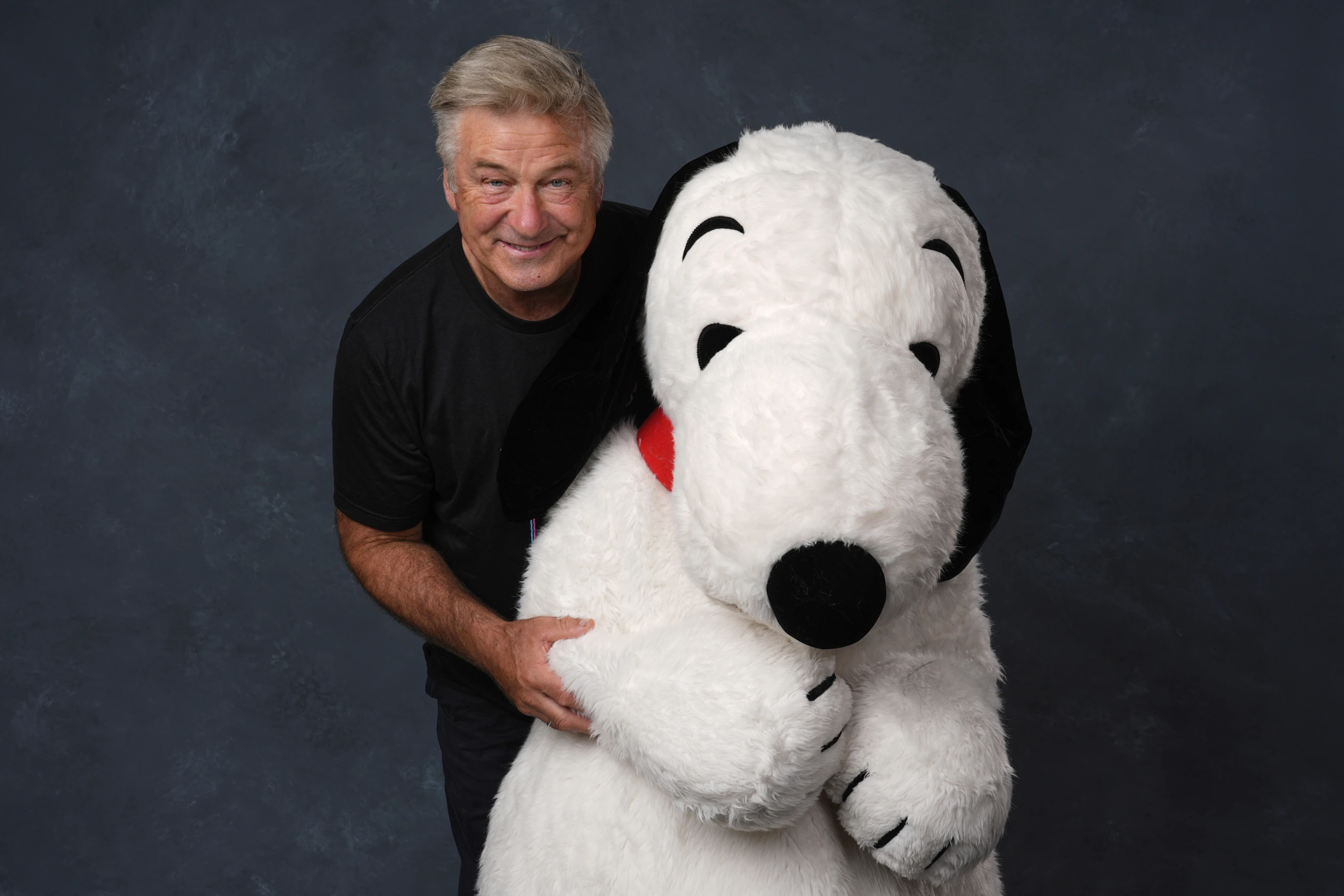 Alec Baldwin, left, and a person dressed as the character Snoopy from “Peanuts” poses for a portrait to promote the 75th anniversary of “Peanuts” during Comic-Con International on Thursday, July 24, 2025, in San Diego. (AP Photo/Chris Pizzello)