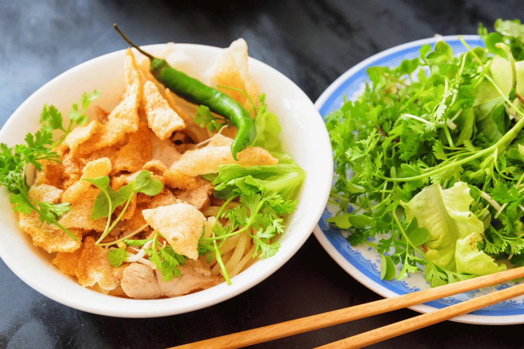 Cao lầu g&acirc;y ấn tượng bởi sự độc đ&aacute;o của sợi m&igrave; dai, phần thịt x&iacute;u thơm ngọt, rau thơm tươi v&agrave; phong vị ri&ecirc;ng kh&oacute; trộn lẫn