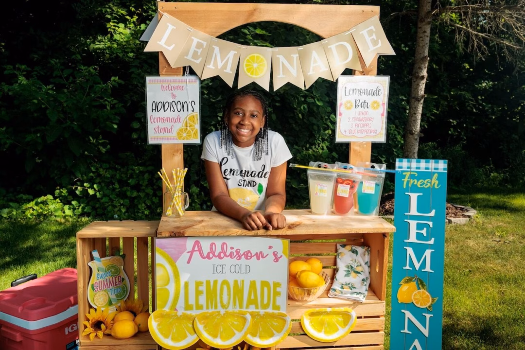 Addison Robinson, 11 tuổi tại quầy nước chanh di động bên ngoài nhà mình ở thị trấn Ypsilanti ngày 3/7. Cô bé đã bán nước chanh đóng gói sẵn từ năm 6 tuổi và tự quản lý một doanh nghiệp hoàn chỉnh bằng tài khoản ngân hàng của riêng mình. Ảnh Jacob Hamilton/MLive.com
