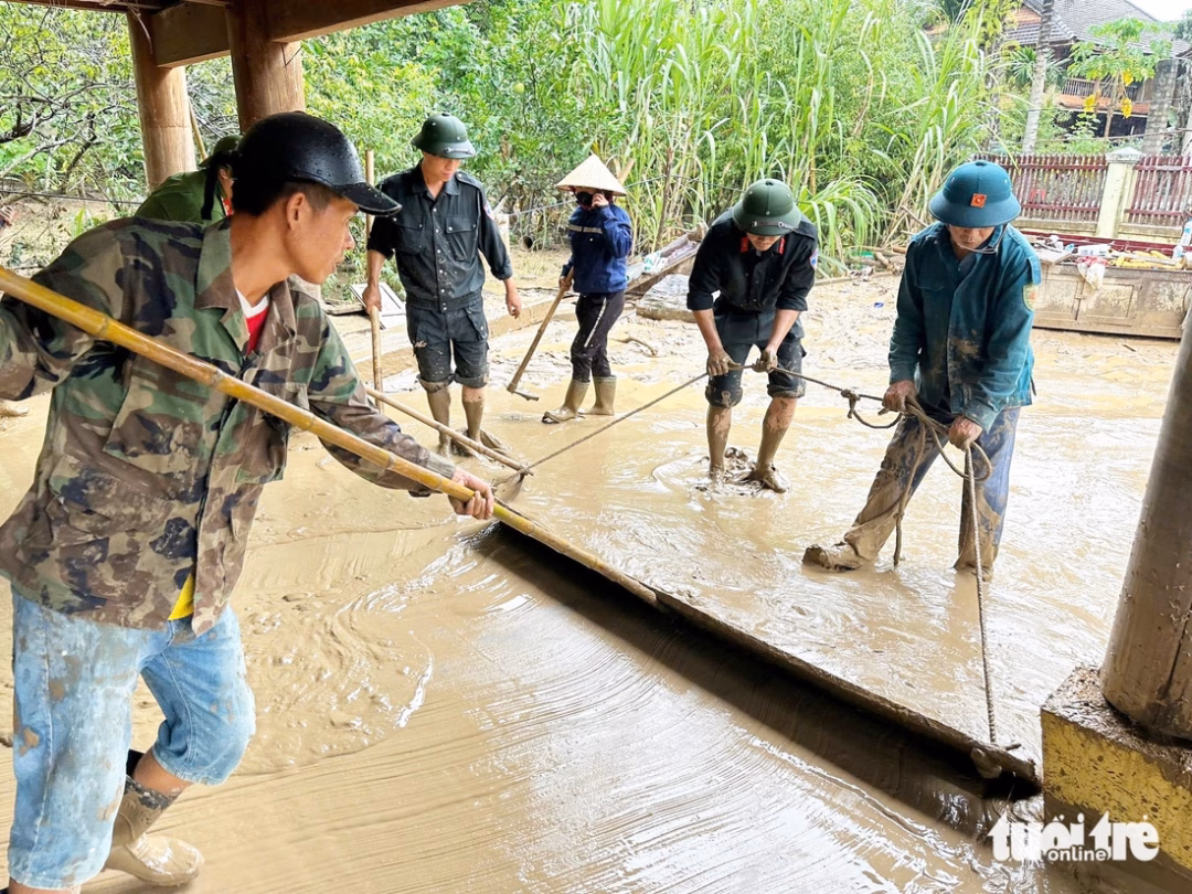 Cứu trợ Nghệ An: Bay thẳng bằng trực thăng thả nhu yếu phẩm vùng lũ Lực lượng công an, bộ đội hỗ trợ người dân dọn dẹp bùn lũ - Ảnh: DOÃN HÒA